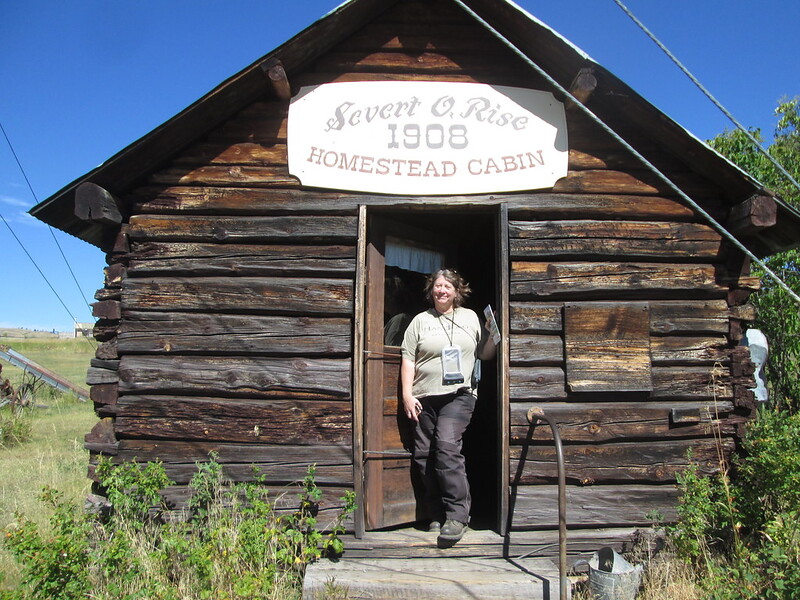 Jayne standing in the doorway of an old homestead cabin.