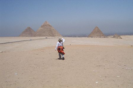 Jayne walking
          in the desert towards the pyramids